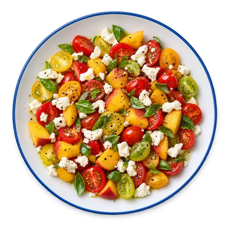 Ensalada de tomate y melocotón con feta y albahaca, correspondiente a la receta que se muestra en CookBook